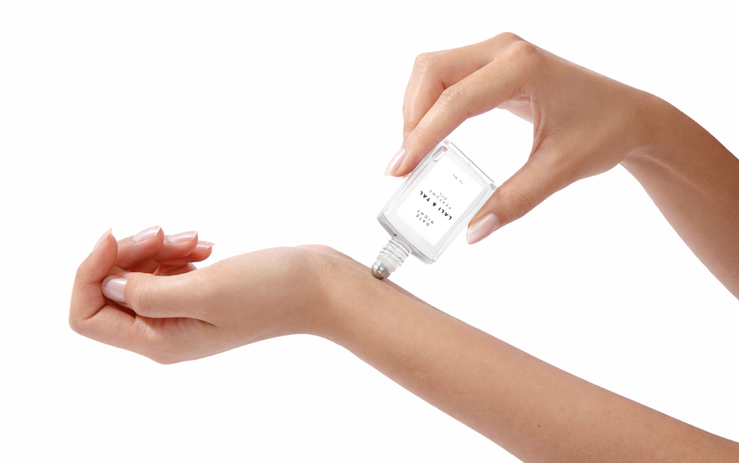 LALI & TAL DATE NIGHT perfume oil being applied to the wrist using a roll-on bottle.