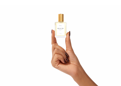 Hand holding a bottle of LALI & TAL FALL perfume oil to show size and scale.