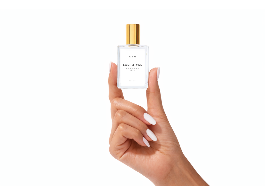 Hand holding a bottle of LALI & TAL GYM perfume oil to show size and scale.