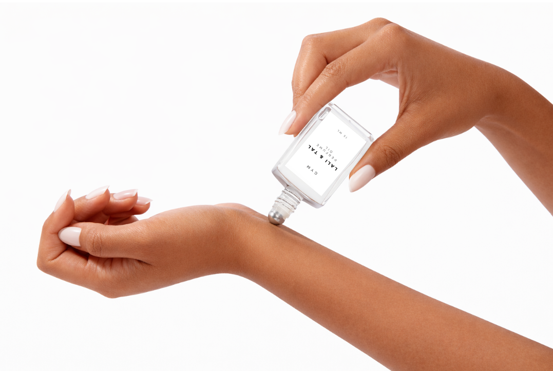 LALI & TAL GYM perfume oil being applied to the wrist using a roll-on bottle.