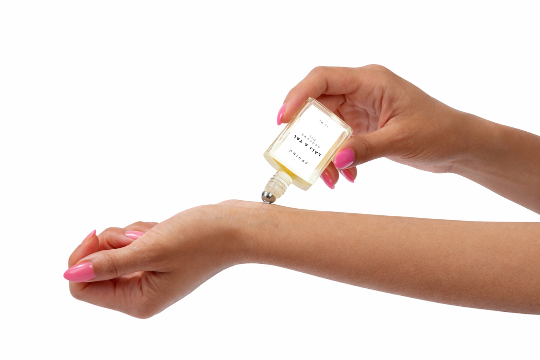 LALI & TAL SPRING perfume oil being applied to the wrist using a roll-on bottle.
