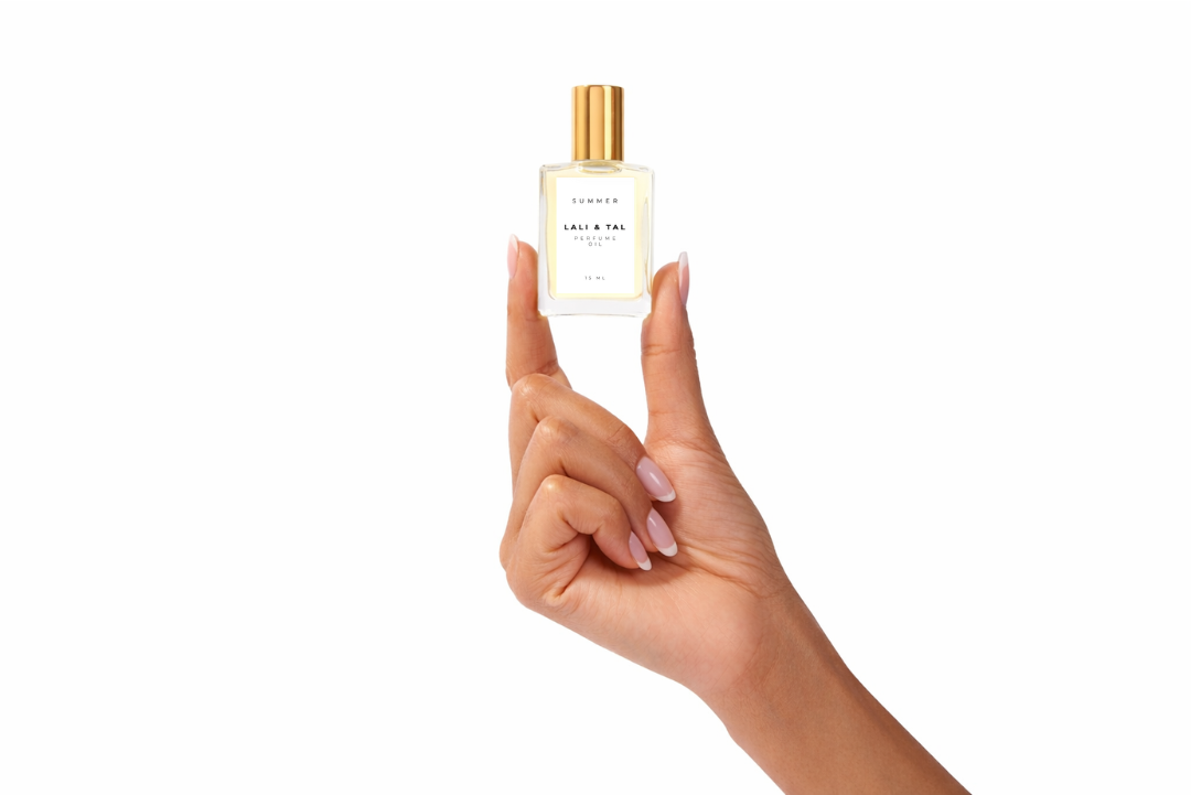 Hand holding a bottle of LALI & TAL SUMMER perfume oil to show size and scale.