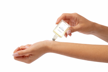 LALI & TAL SUMMER perfume oil being applied to the wrist using a roll-on bottle.