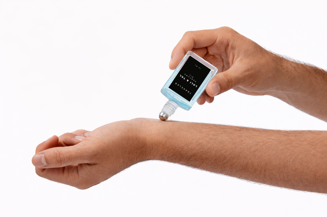 LALI & TAL TRAVELER perfume oil being applied to the wrist using a roll-on bottle.