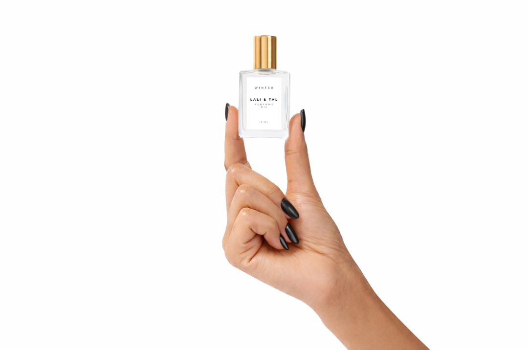 Hand holding a bottle of LALI & TAL WINTER perfume oil to show size and scale.